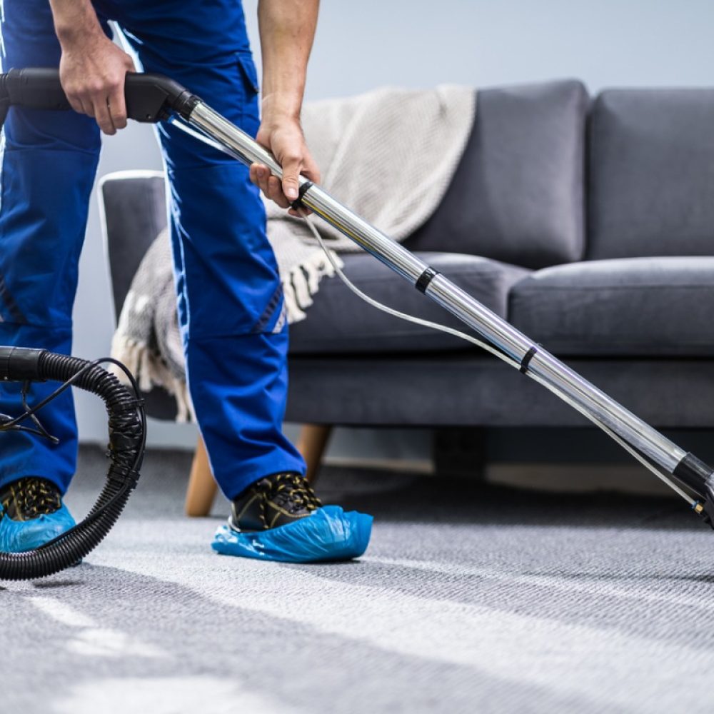 person-cleaning-carpet-with-vacuum-cleaner-picture-id1191080465